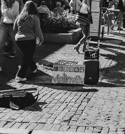 Low section of woman standing on sidewalk