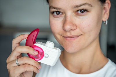 Close-up of young woman holding dentures