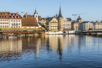 Luzern is reflected on the river on a sunny day with the chapel bridge