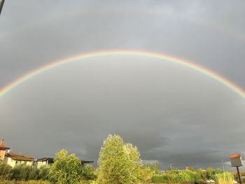 Rainbow over building against sky