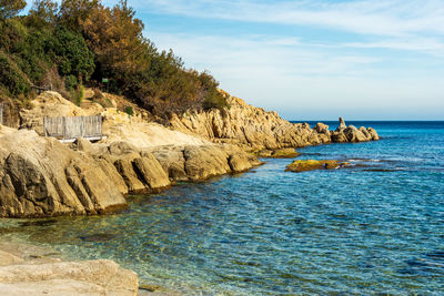 Rock formations by sea against sky