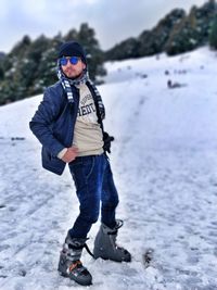 Portrait of man wearing sunglasses standing in snow