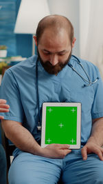 Man using digital tablet while sitting at home