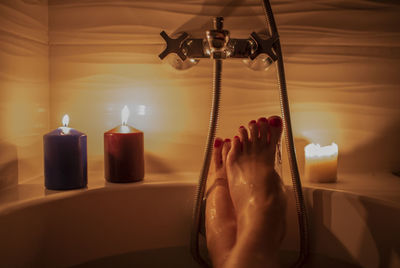 Close-up of hand holding illuminated candles