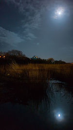 Scenic view of lake against sky at night