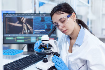 Female dentist examining chemical in laboratory