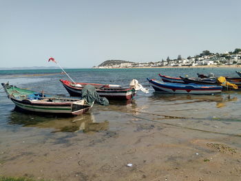 Boats moored on sea against clear sky