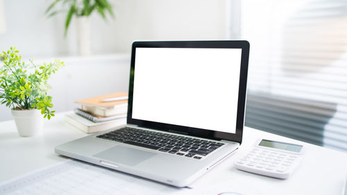 Midsection of woman using laptop on table