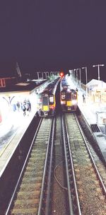 Train at railroad station against clear sky at night