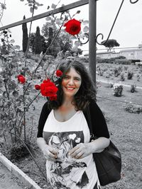 Portrait of smiling young woman standing against trees