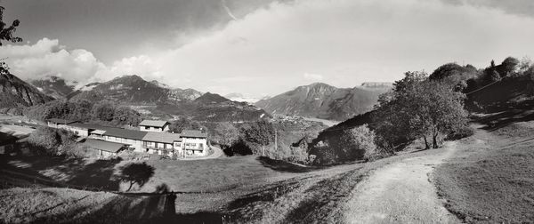 Panoramic shot of road by buildings against sky