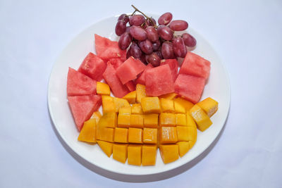 High angle view of chopped fruits in plate on table