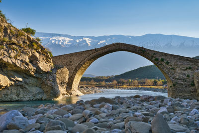 Kadiut bridge in the region of permet with view on the snowy mountain range