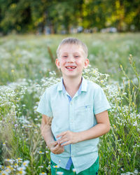 Portrait of boy standing against plants