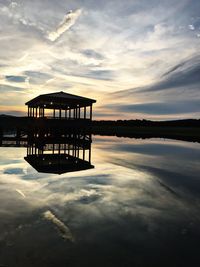 Pier on lake against sky during sunset