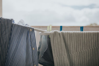 Close-up of clothing drying on clothesline in balcony