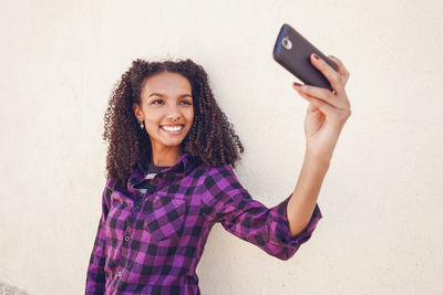 Portrait of smiling young woman using mobile phone