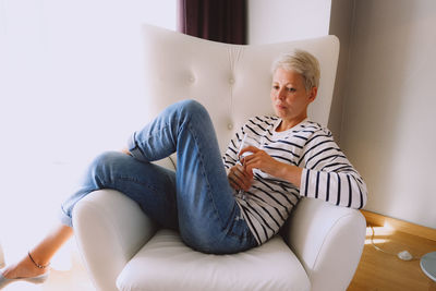 Young woman sitting on sofa at home
