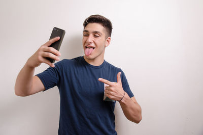 Young man using mobile phone against white background