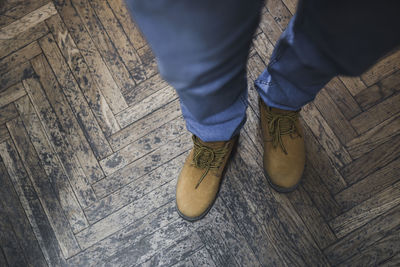Low section of man standing on hardwood floor