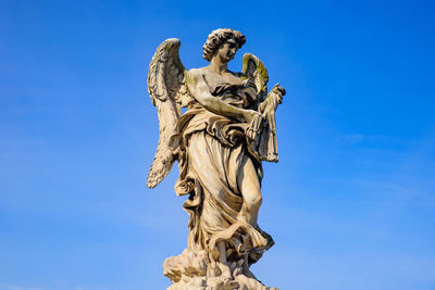 Low angle view of statue against blue sky