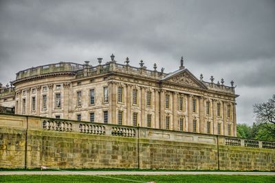 Facade of historical building against cloudy sky