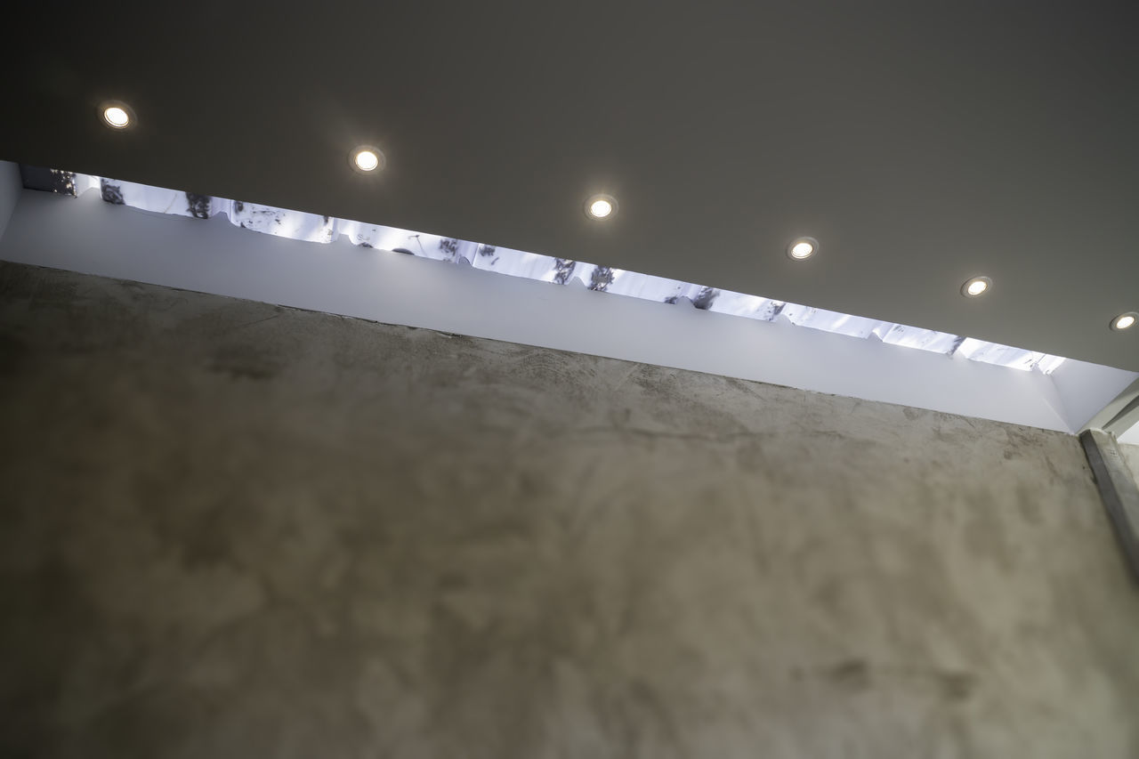 LOW ANGLE VIEW OF ILLUMINATED LIGHTS AT AIRPORT