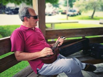 Man sitting on guitar at park