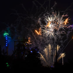 Low angle view of firework display at night