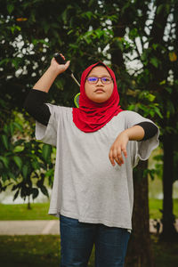 Young hijab asian girl playing badminton at the park.