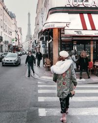 Rear view of people walking on city street