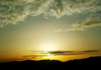 Scenic view of silhouette mountains against sky at sunset