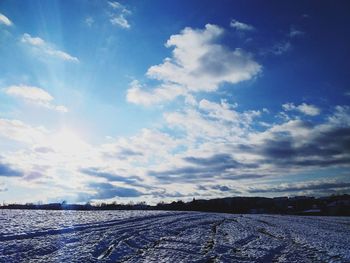 Scenic view of snowy field against sky