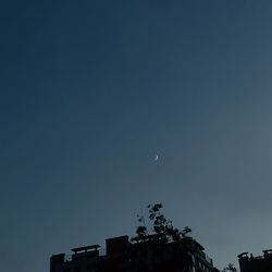 Low angle view of silhouette building against sky at night