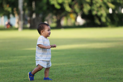 Full length of cute baby boy walking at park