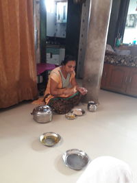 Midsection of woman sitting on table at home