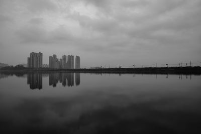 Reflection of buildings in lake against sky