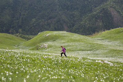 Rear view of woman walking on field