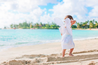 Rear view of woman standing on beach