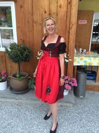 Portrait of woman wearing dirndl standing outside house