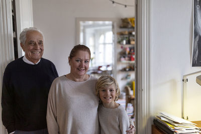 Portrait of happy grandparents with grandson at home