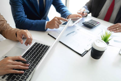 Midsection of man using laptop on table