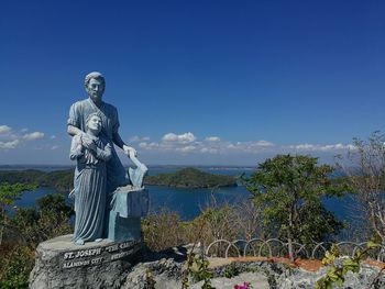 Statue by trees against sky