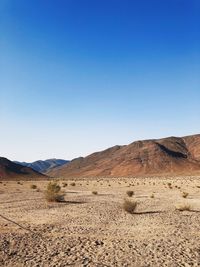 Scenic view of desert against clear blue sky