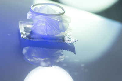 Close-up of condom with packet on table