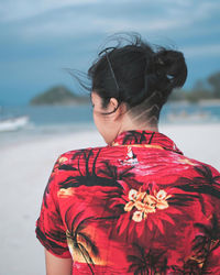 Rear view of woman standing at beach