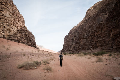 Rear view of man walking on rock