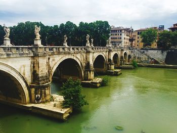 Bridge over river against built structures