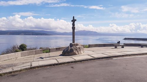 Statue by sea against sky