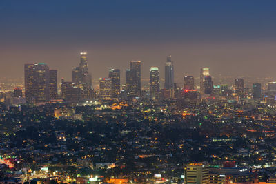 Illuminated cityscape against sky at night